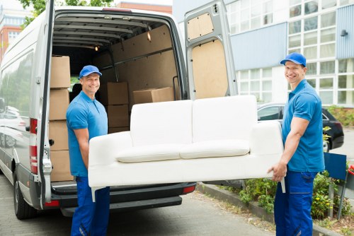 Professional team handling piano removals in Barnet with protective equipment